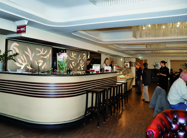  Café Schlossblick – Marquardtbau Stuttgart  Das legendäre ehemalige Café Marquardt hatte seine besten Zeiten hinter sich, als vom Eigentümer zusammen mit dem neuen Pächter das Café Schlossblick aus der Taufe gehoben wurde. Mitten in Stuttgart, am Schlossplatz, mit Blick auf den Königsbau, das neue und alte Schloss gibt es im historisch, denkmalgeschützten „Marquardtbau“ ein gelungenes gastronomisches Konzept im ehemals „königlichen“ Hotel (erbaut im Jahre 1872 von Prof. August Bayer). Die gesamten Gasträume mit Küche und Nebenräumen wurden technisch und optisch unter Berücksichtigung der historischen Substanz ins 21. Jahrhundert katapultiert. Ein faszinierendes Beleuchtungskonzept, Ledersessel im Retrolook, Raucherlounge und Nebenräume für Veranstaltungen aller Art machen das Café Schlossblick zu einer angesagten Location für alle Gelegenheiten.  Planungsbeginn: 2006 Fertigstellung: 2007  Denkmalgeschützte Fassade 